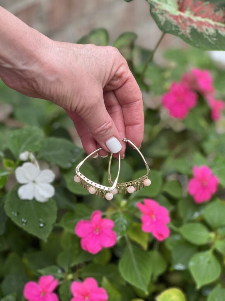 Time and Tru Walmart real gemstone summer earrings held by a woman's hand in front of a pot of flowers