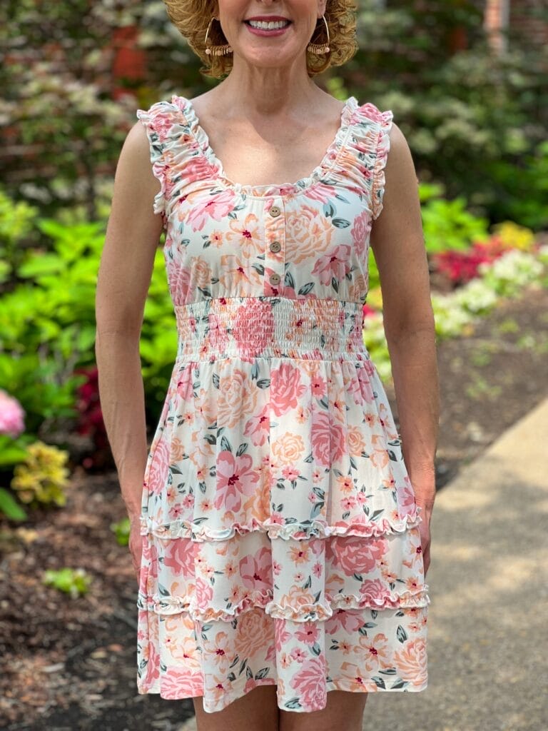 woman standing in a garden wearing No Boundaries Juniors Sleeveless Ruffle Dress