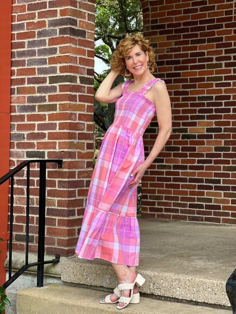 woman standing on stairs outdoors wearing Time and Tru Women's Smocked Midi Dress with Ruffle Straps from Walmart in pink madras plaid