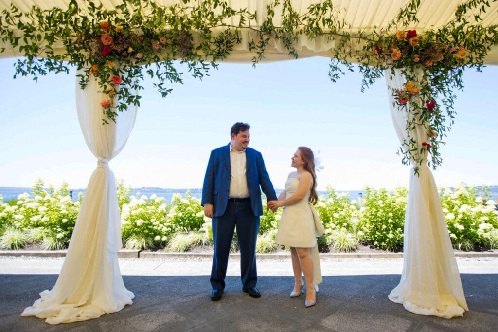 couple under an arch decorated with greenery