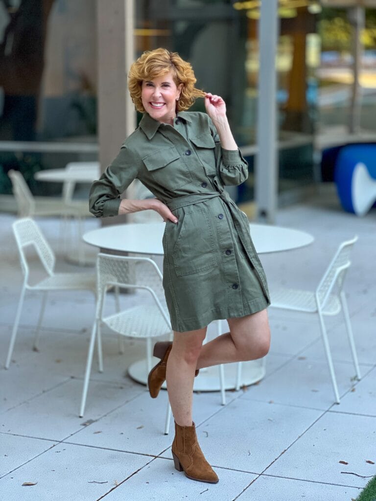 woman wearing fall transition dress and brown booties standing on one leg