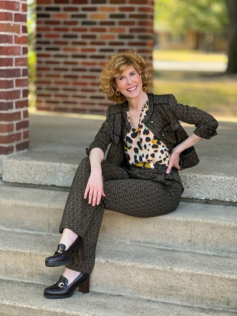 woman sitting on stairs wearing cabi suit and easy spirit loafer pumps