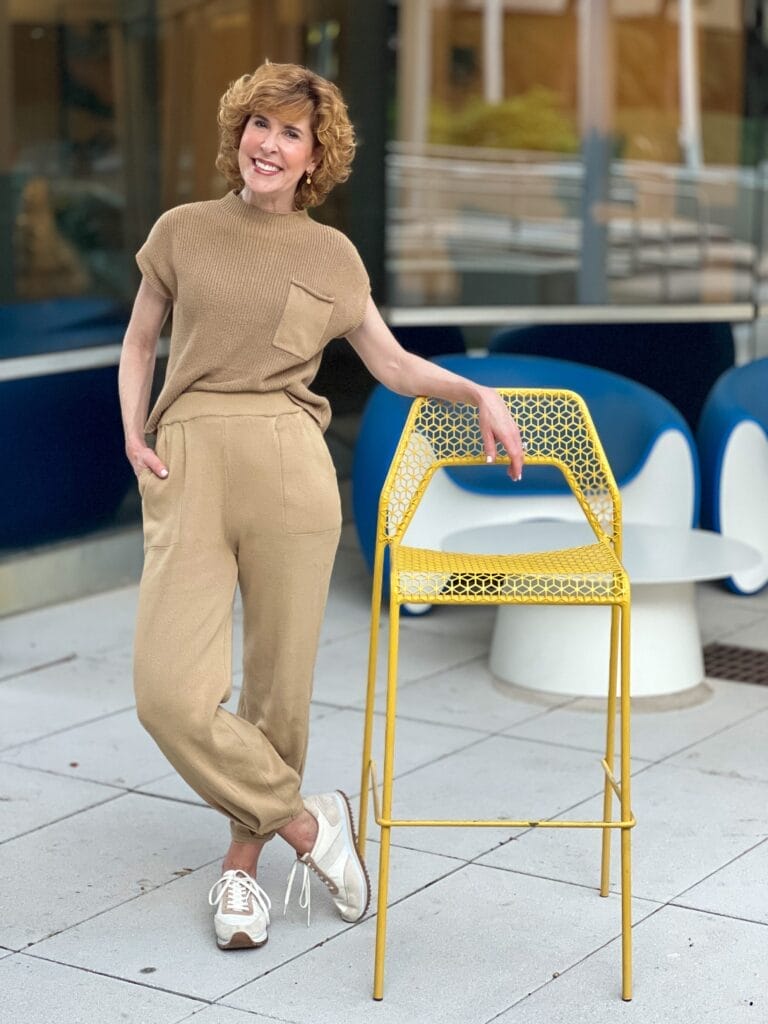 woman standing by a tall yellow chair wearing a tan 2-piece Amazon set