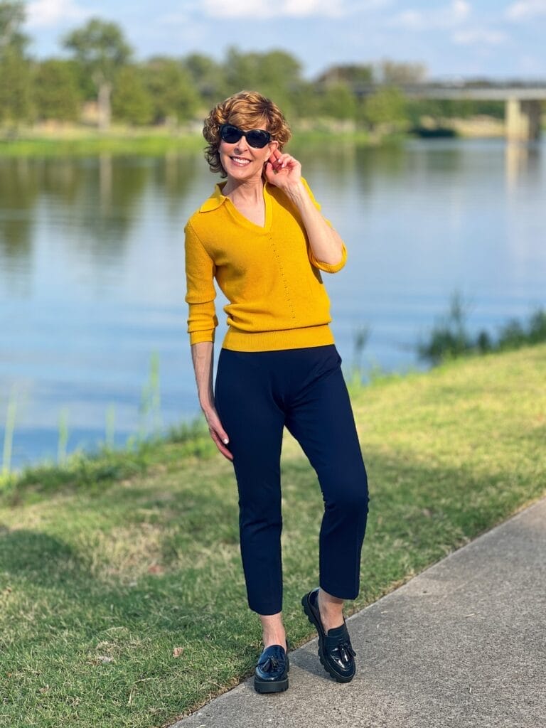 woman wearing gold johnny collar sweater from talbots and navy montauk pants with navy loafers