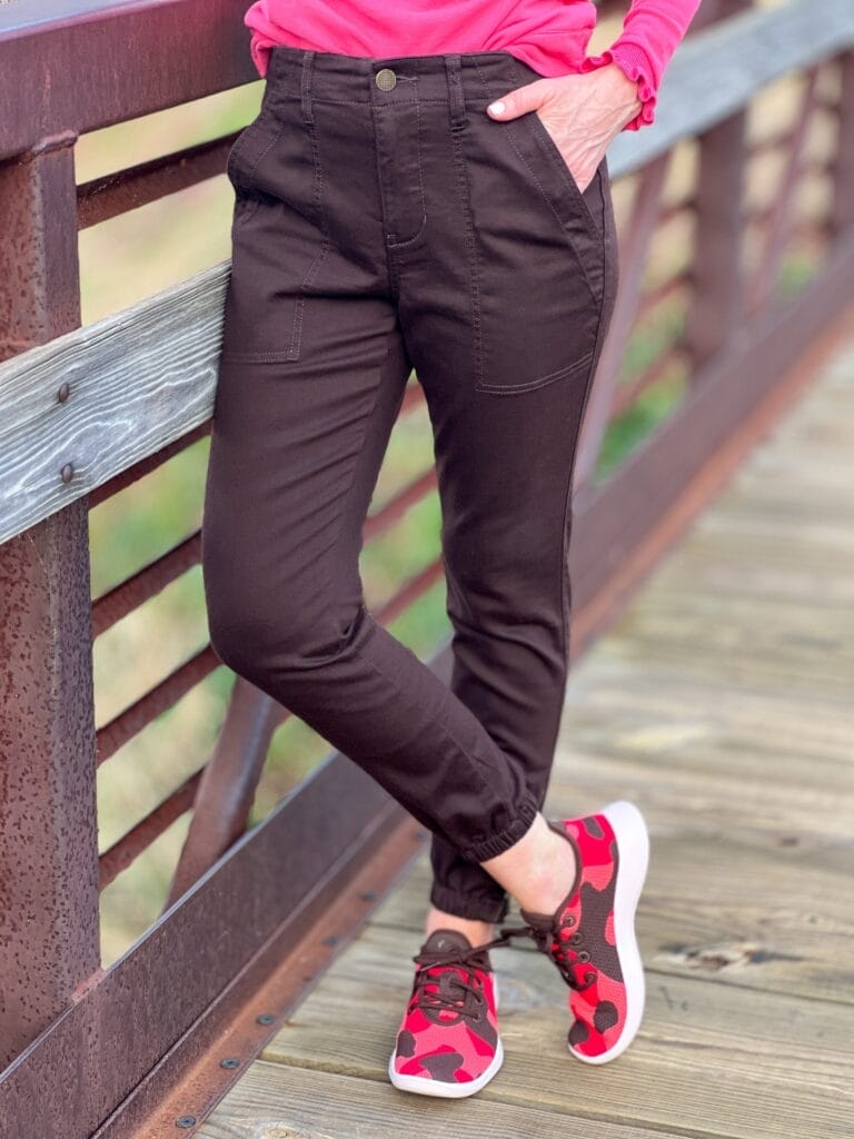 woman's legs wearing cargo joggers and orange and brown camo allbirds sneakers