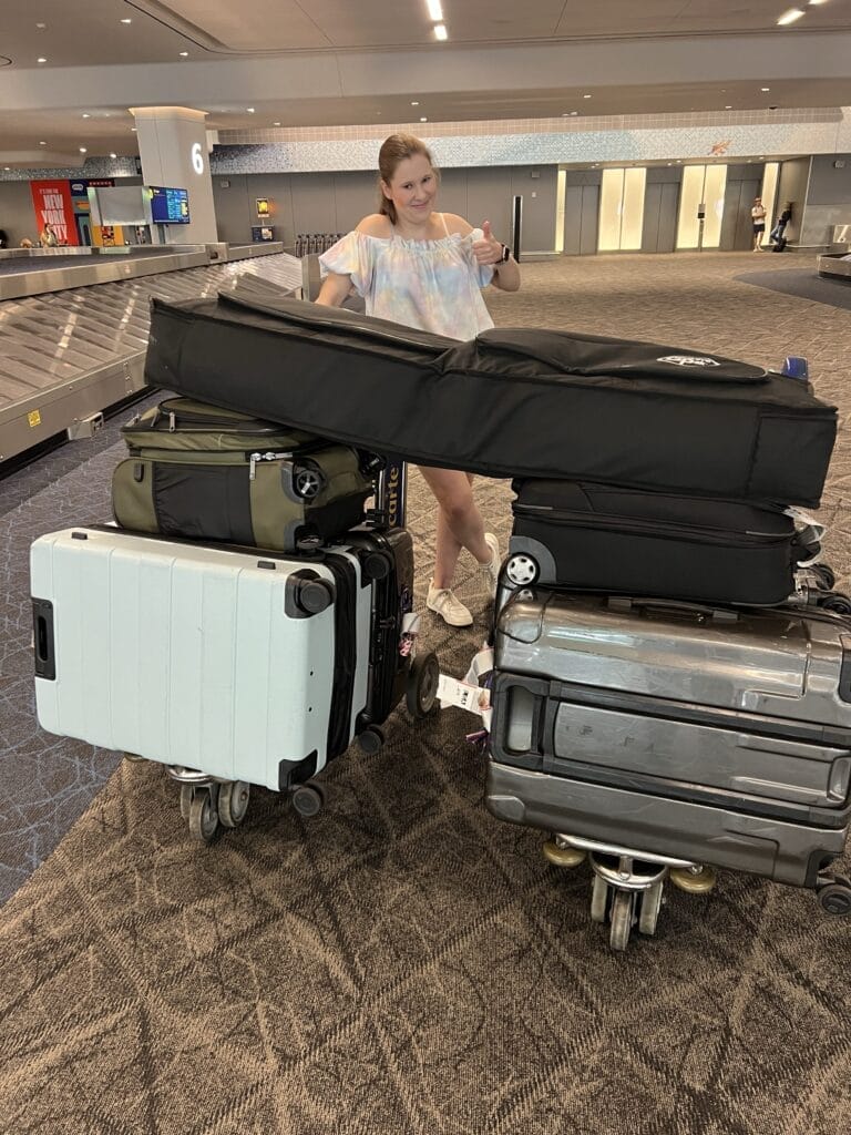 Woman standing behind two carts full of luggage in LGA airport