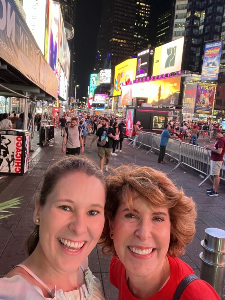 woman and daughter taking a selfie in times square in nyc