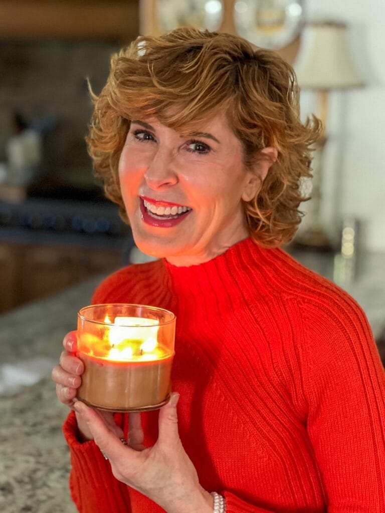 woman wearing orange talbots sweater with the best fall candles