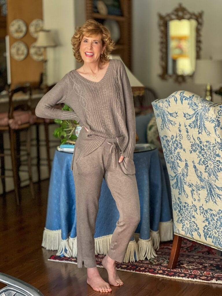woman standing in living room wearing brown loungewear set in taupe