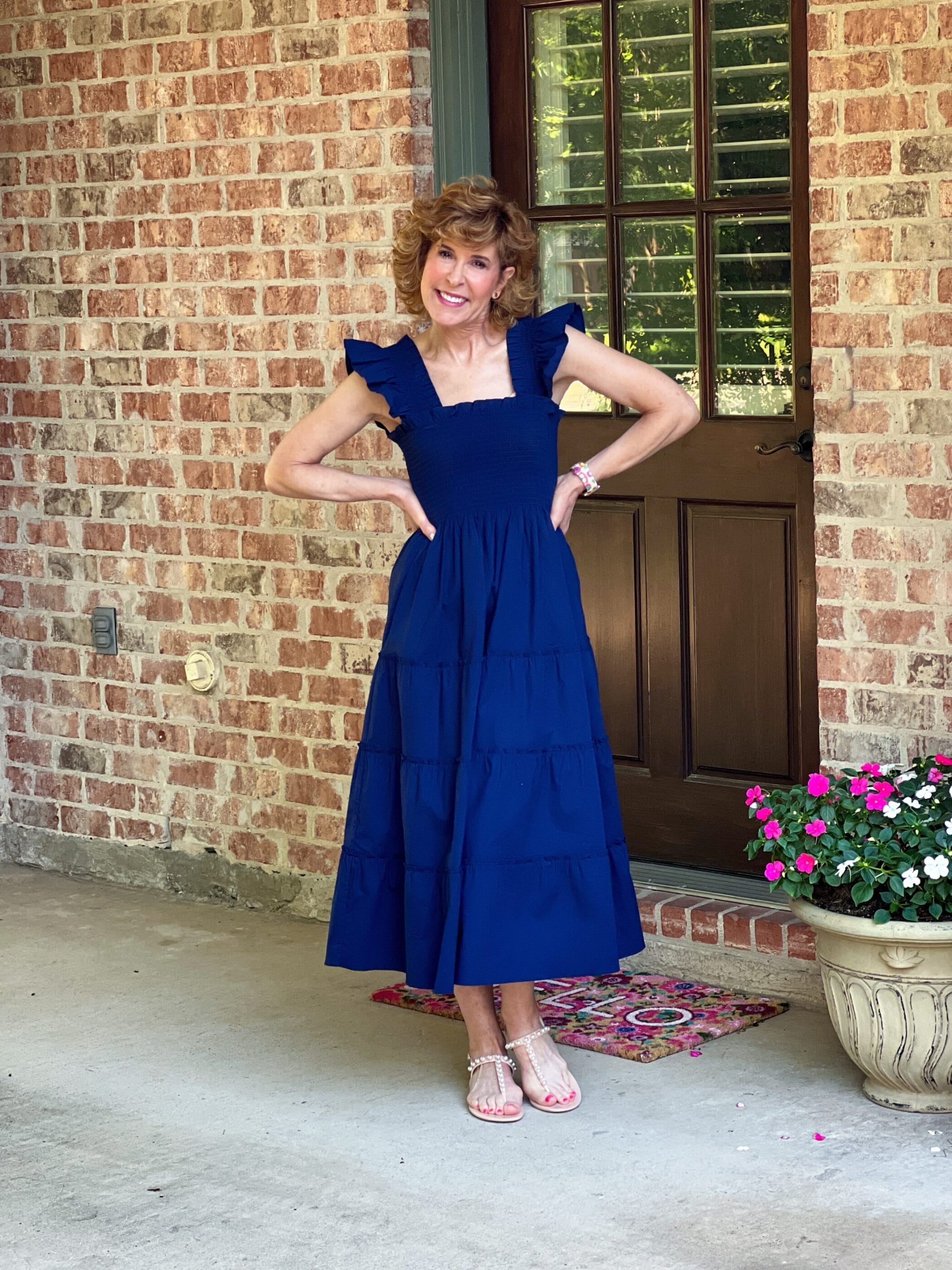 woman standing on driveway wearing hill house home nap dress in navy