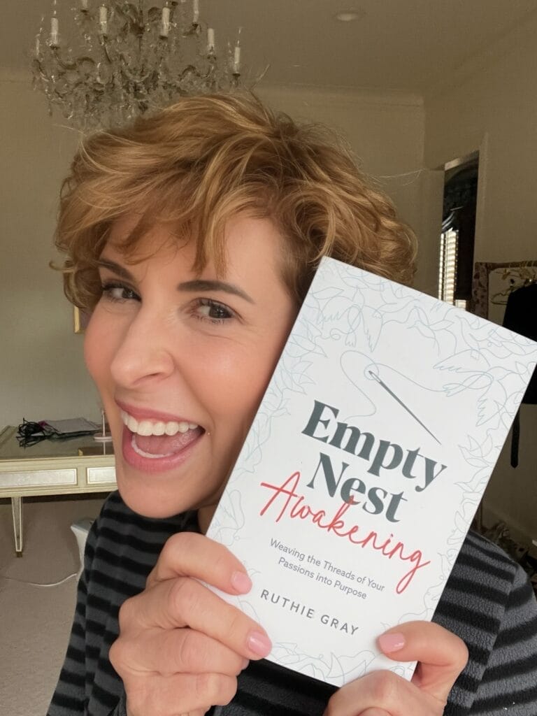 woman with photo of empty nest awakening book by ruthie gray