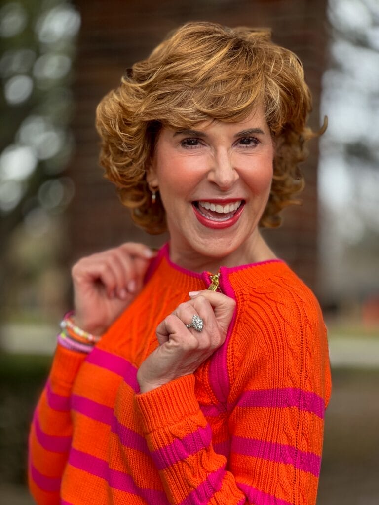 woman over 50 wearing orange sweater