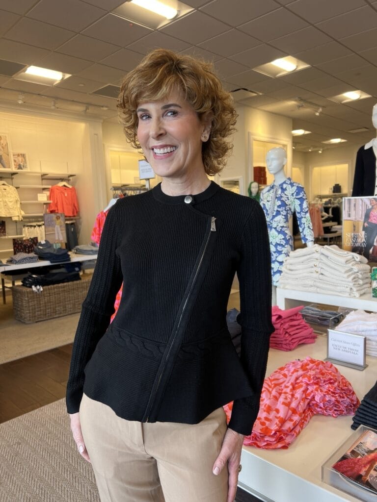woman wearing black peplum sweater in a talbots store