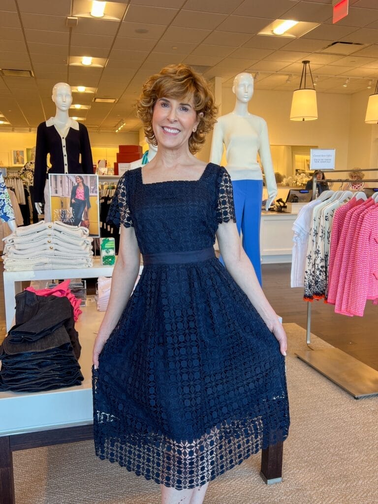woman wearing blue lace overlay dress standing in talbots