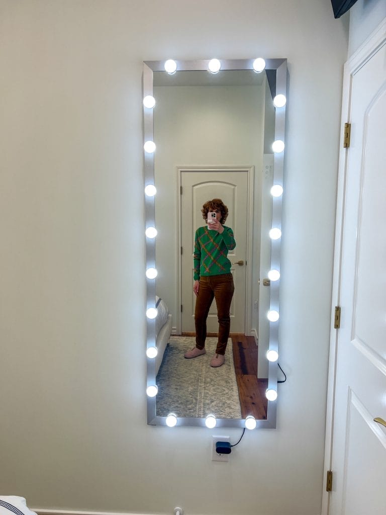woman taking a selfie in a lighted mirror