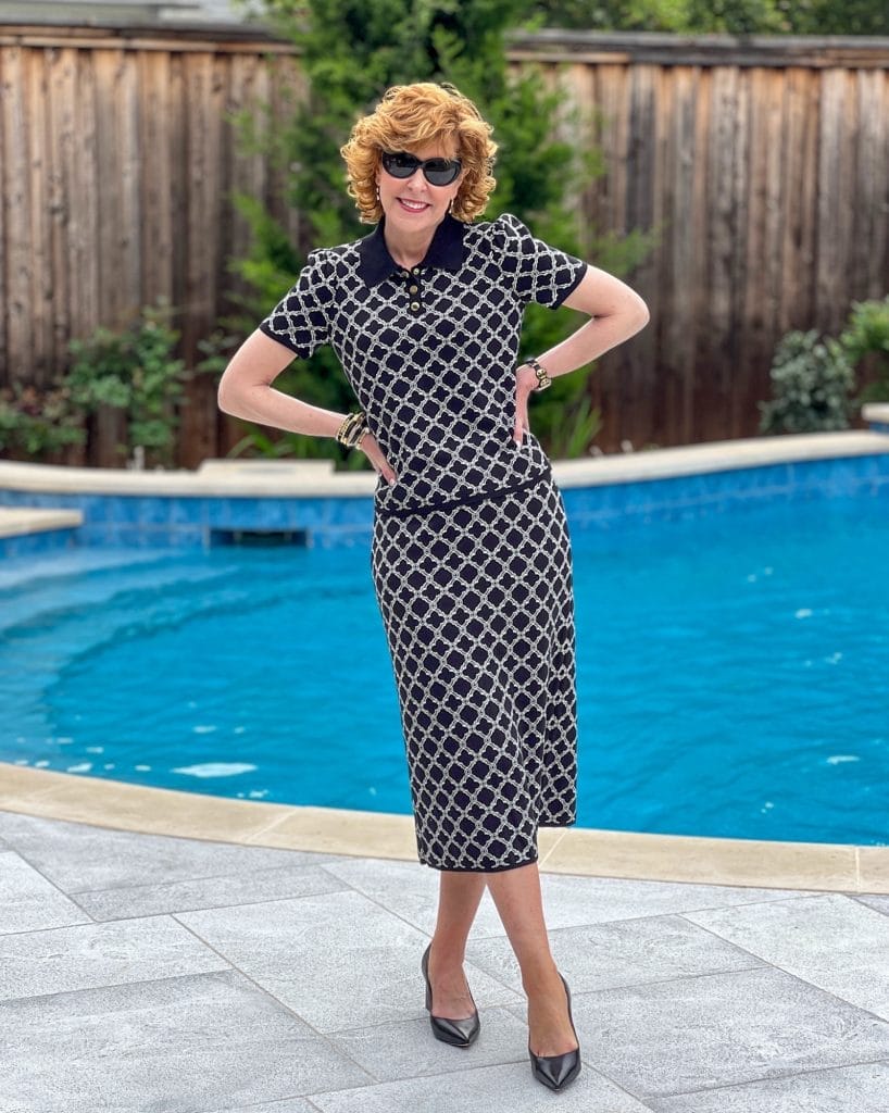 woman standing by a pool wearing talbot 2 piece set and marc fisher block heel pumps