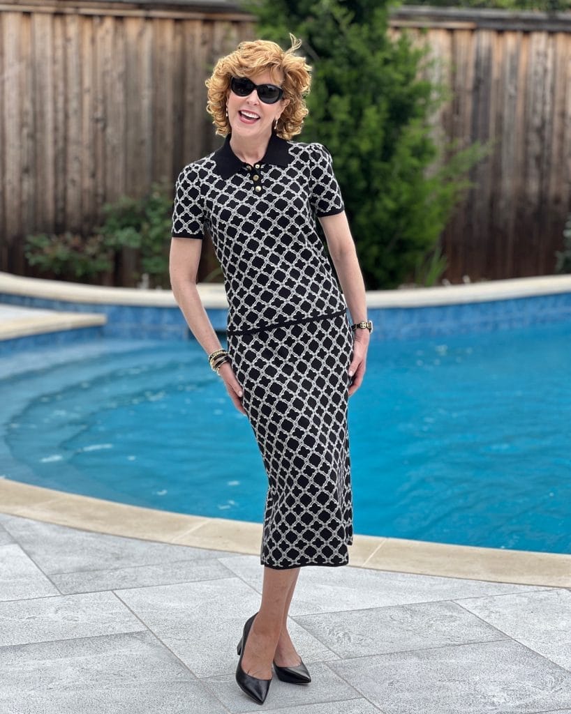 woman standing by a pool wearing talbot 2 piece set and marc fisher block heel pumps