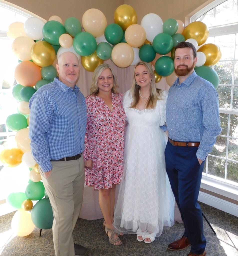 Family standing in front of a balloon arch celebrating a wedding shower