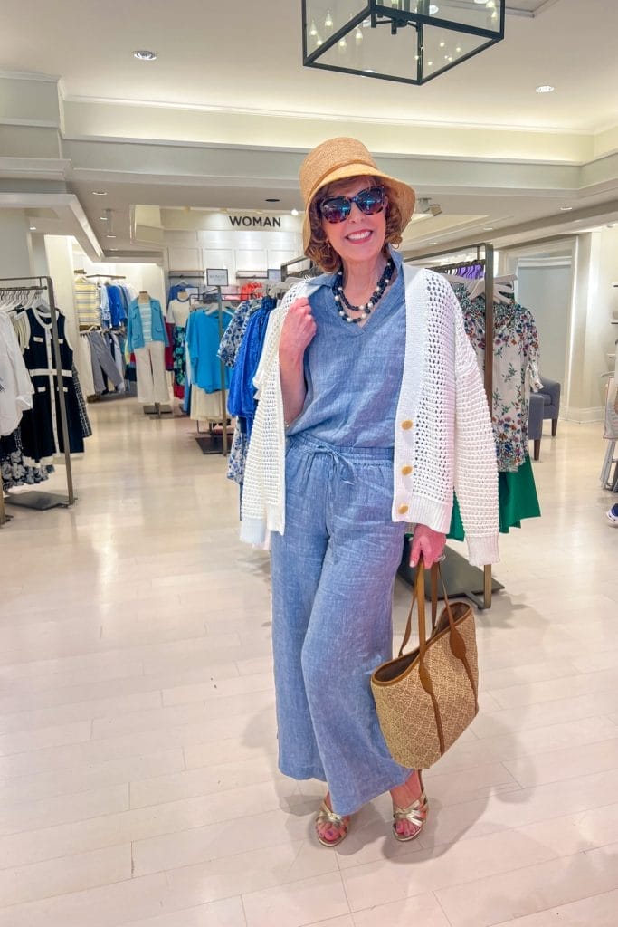 woman over 50 standing in talbots store wearing chambray outfit with white cardigan