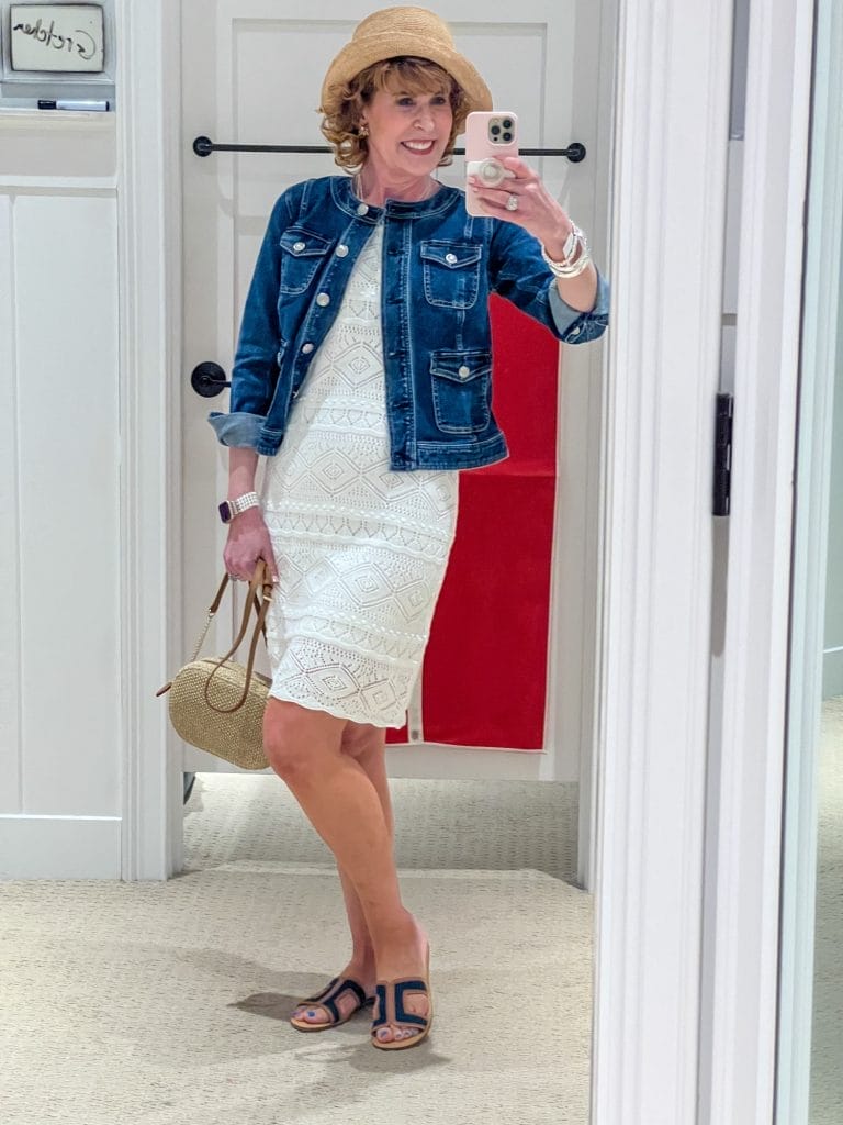 woman taking selfie in talbots dressing room wearing white crochet dress and denim jacket