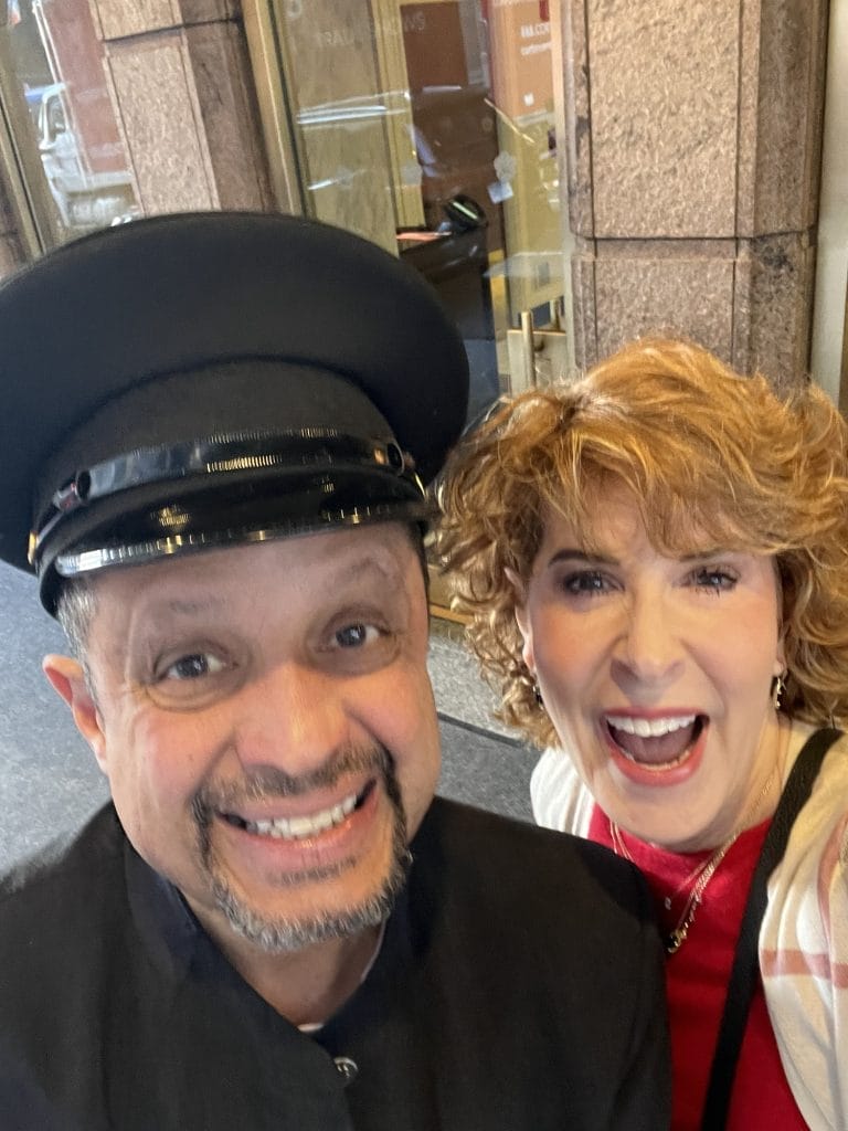 woman pictured with lenny the doorman at the omni berkshire place in nyc