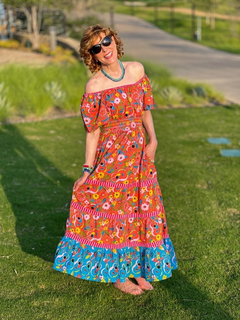 woman standing in bare feet on grass wearing printfresh off the shoulder dress