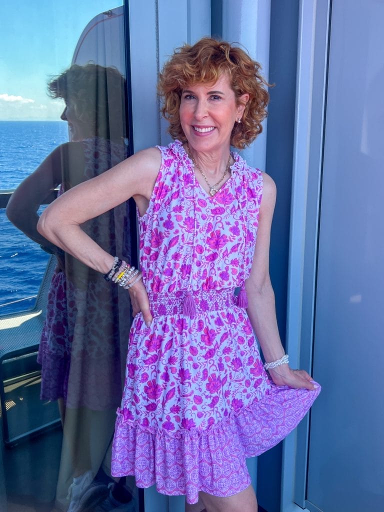 woman standing on balcony of a cruise ship wearing cabana life smocked waist dress in provence pattern