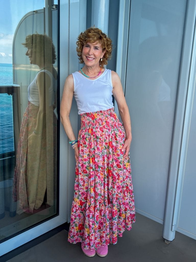 woman standing on balcony of a cruise ship wearing convertible dress as a skirt with white vneck tank from talbots