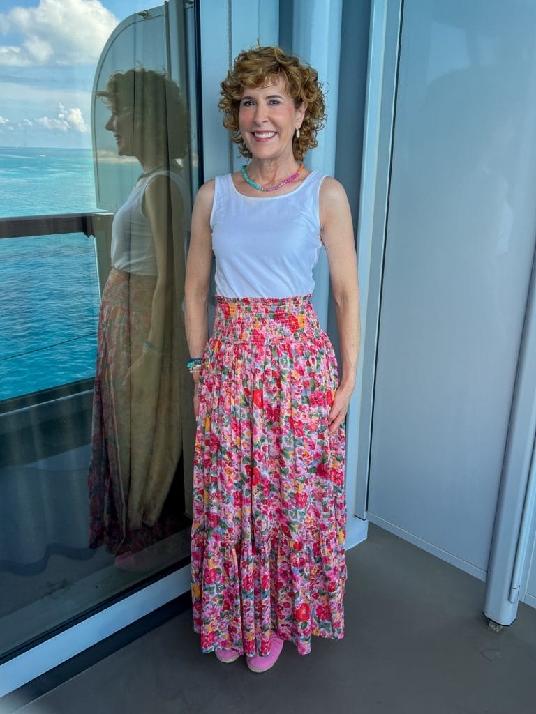 woman standing on balcony of a cruise ship wearing convertible dress as a skirt with white scoop neck tank from talbots