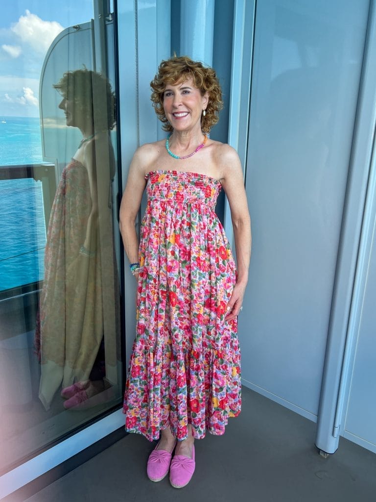 woman standing on balcony of a cruise ship wearing convertible dress as strapless