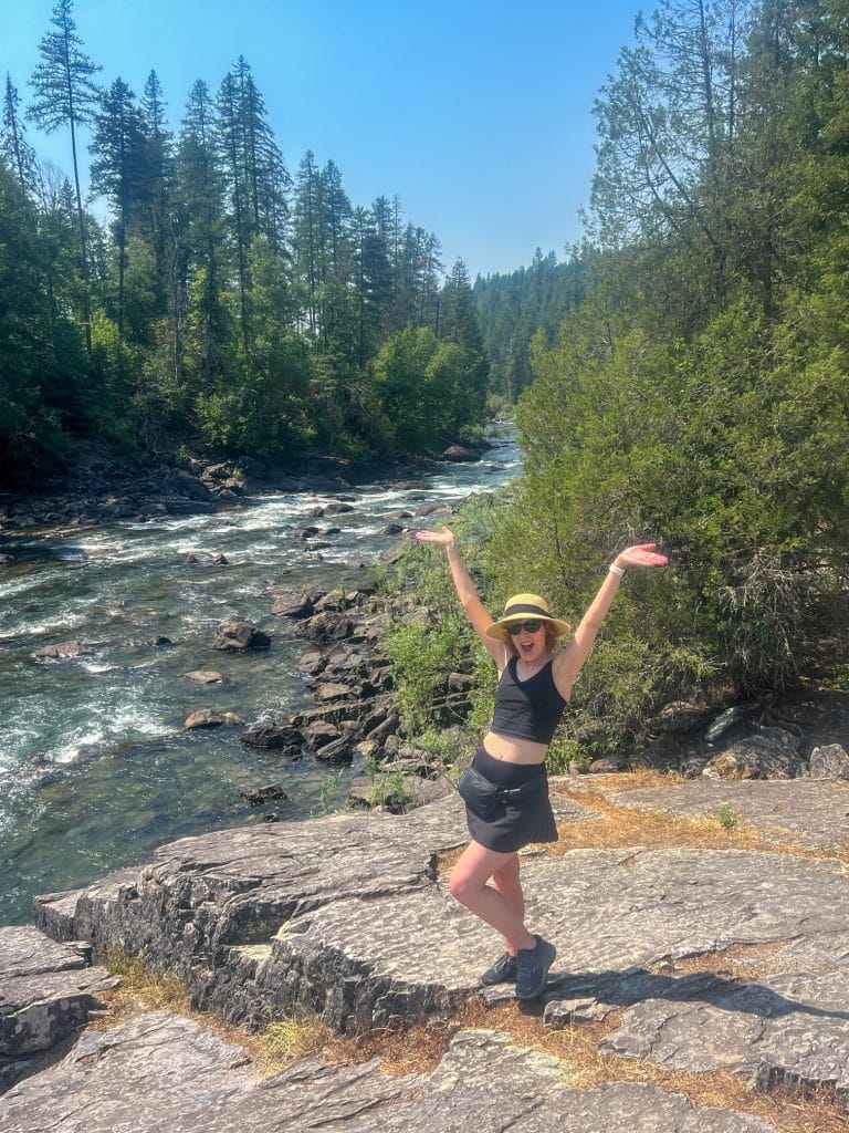 woman in black workout bra and skort near swan river in montana