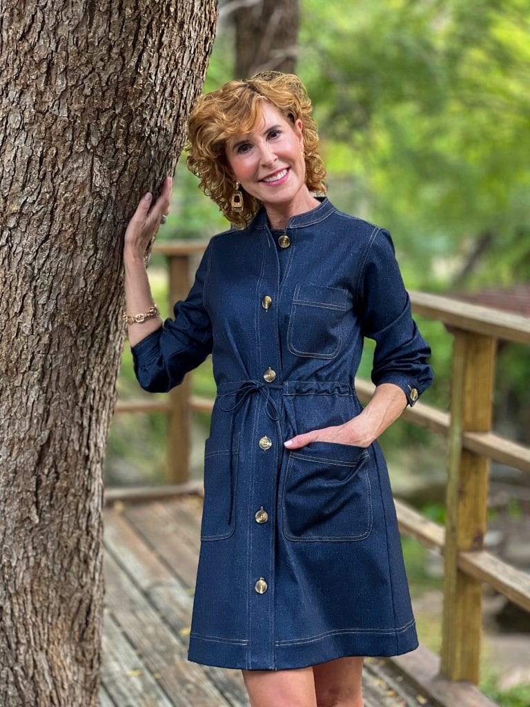 woman standing by a tree wearing jude connally gina dress in denim