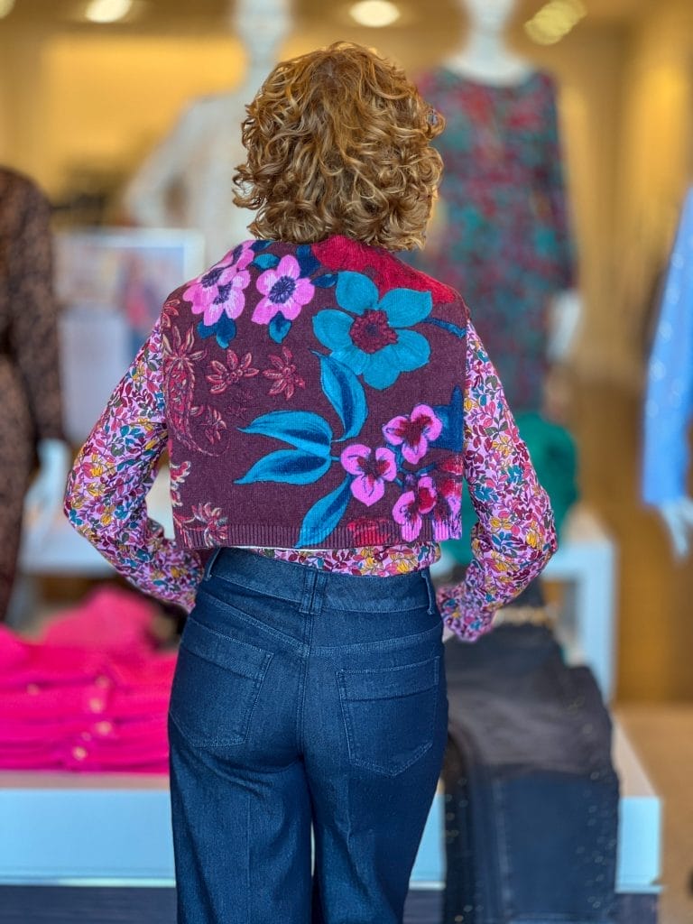 woman over 50 from the back standing in a talbots store wearing floral sweater over her shoulders