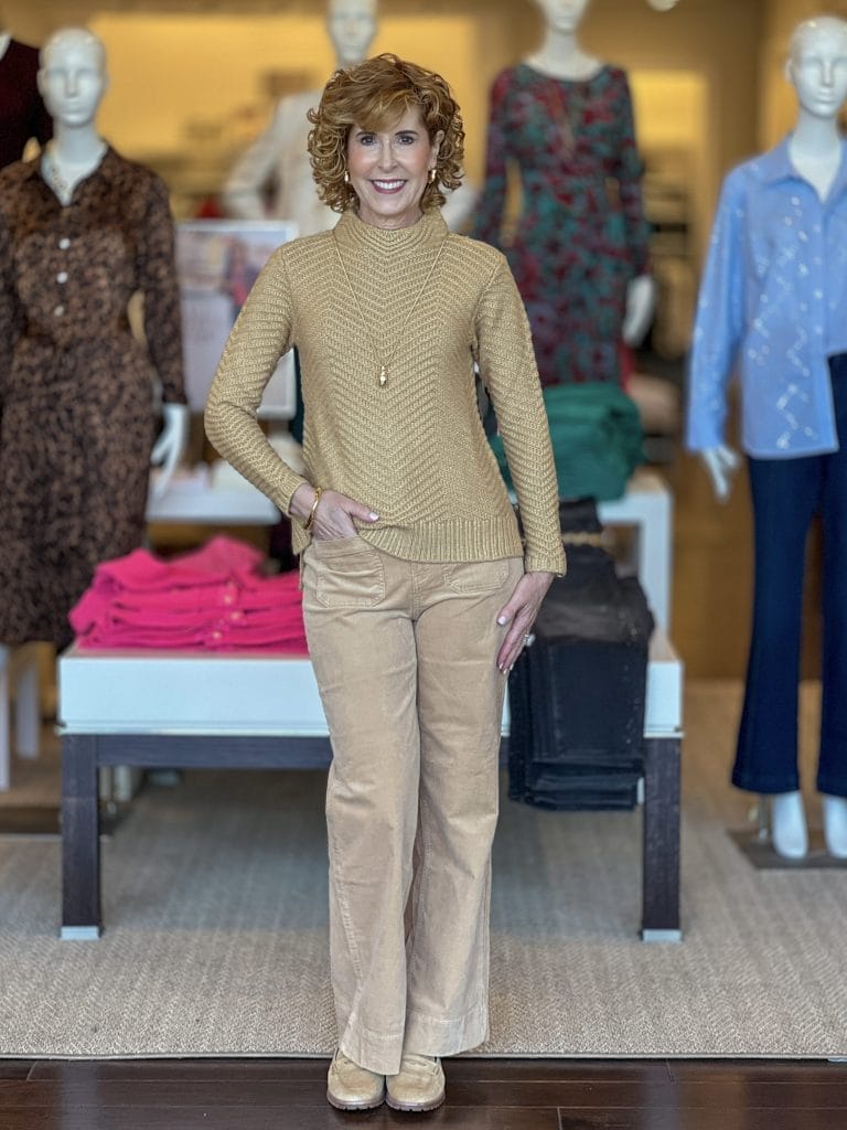 woman over 50 standing in a talbots store wearing a textured pullover and wide leg corduroy pants