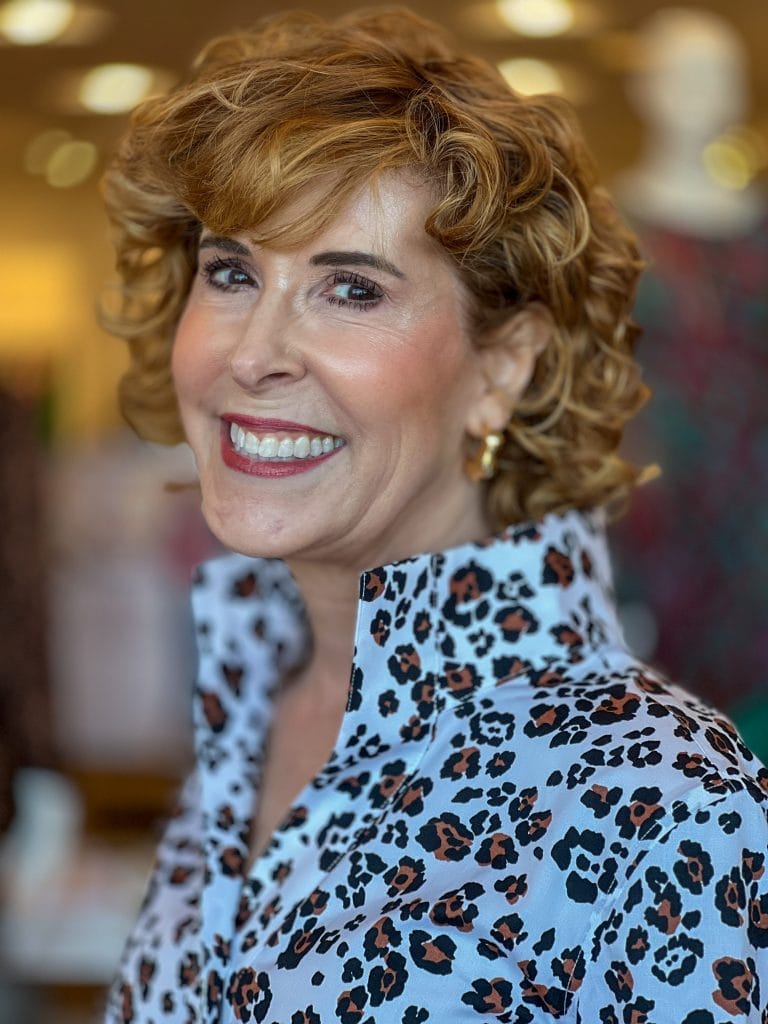 woman over 50 wearing leopard print popover with stand up collar