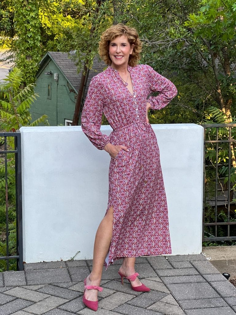 woman standing by a white wall wearing Camden Geo Button Down Maxi Dress from cabana life