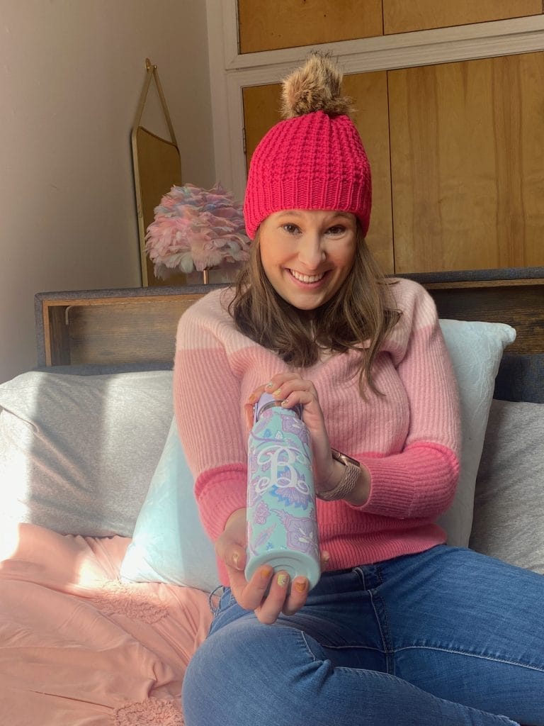 girl wearing pink hat holding water bottle