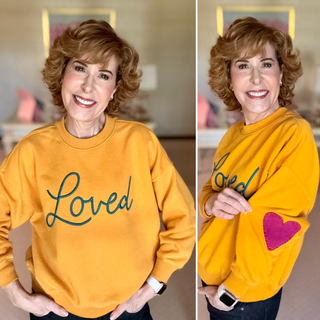 woman over 50 wearing yellow LOVED sweatshirt