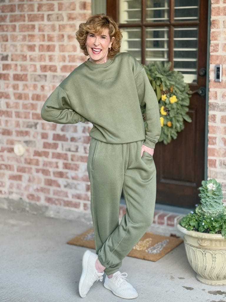 woman wearing cozy earth city scape loungewear set in green standing by back door